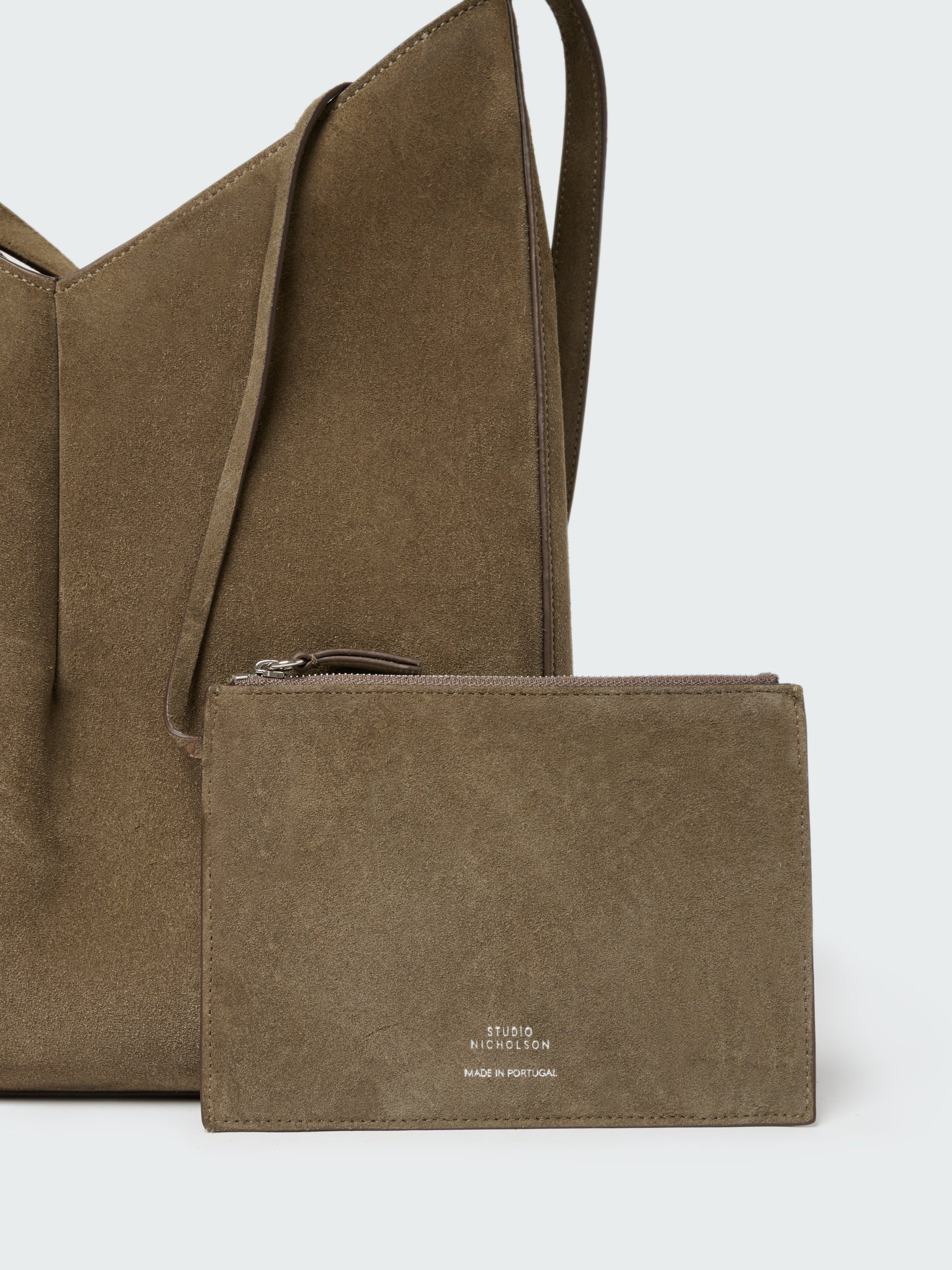 Brown suede handbag with matching pouch on a light gray background